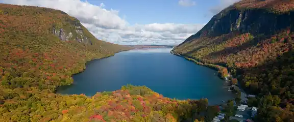 Lake Willoughby between steep hills covered in fall foliage, Vermont